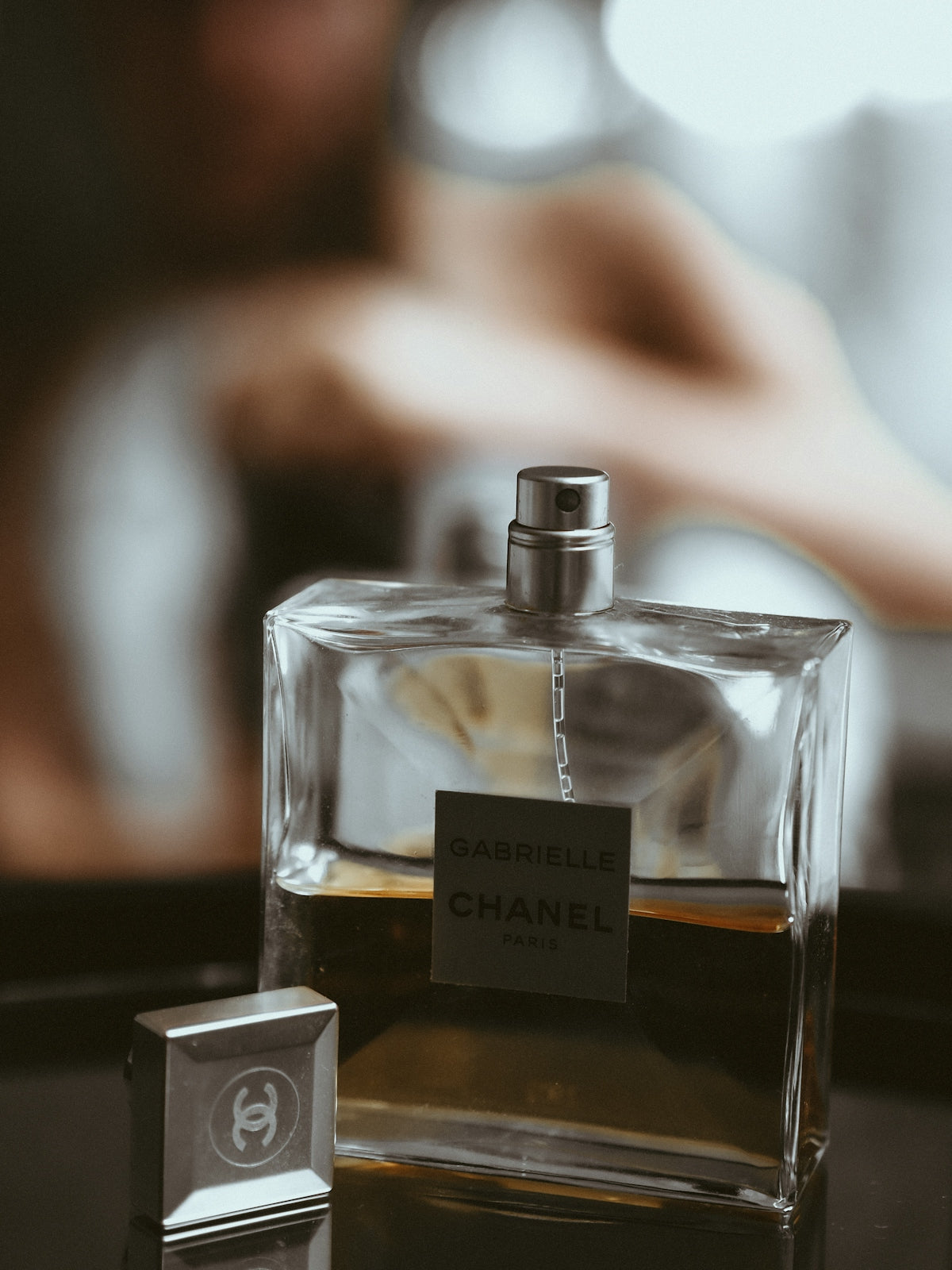clear glass perfume bottle on black table